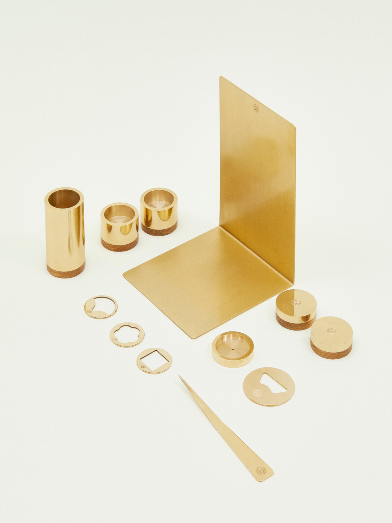 Monocle brass stationery range displayed flat with pen pot, candleholders, bookend, keyrings, bottle opener, letter opener, incense plate and paperweights.