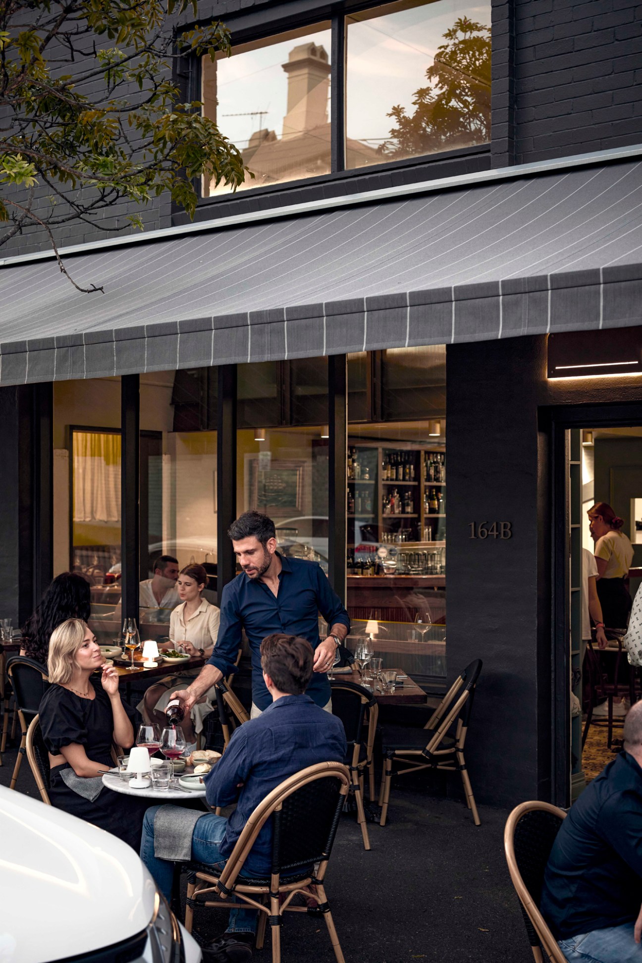 Diners seated at outdoor tables under an awning at Mosconi restaurant in Brisbane