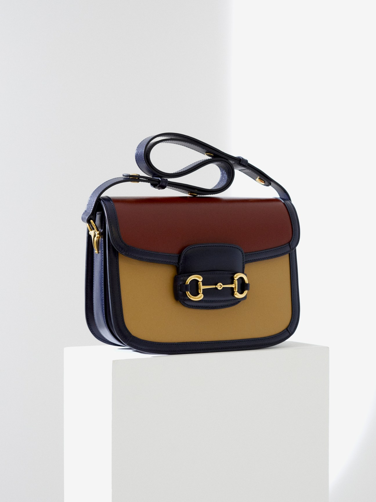 Colorful handbag by Gucci on white surface