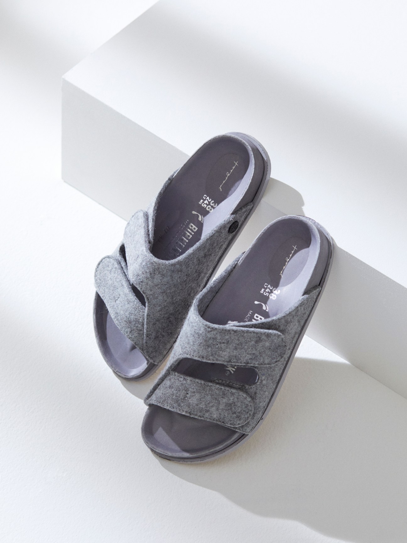 Grey felt sandals by Birkenstock x Faye Toogood on white geometric blocks