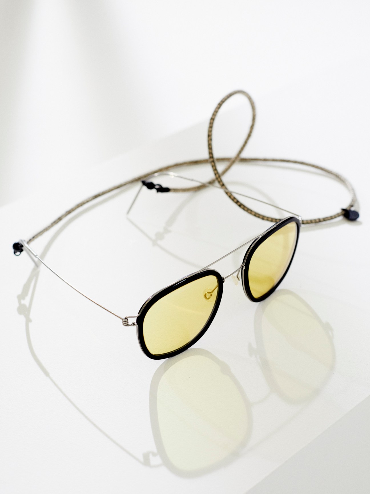 Sunglasses by Lindberg with cord by Diffuser Tokyo on reflective white surface