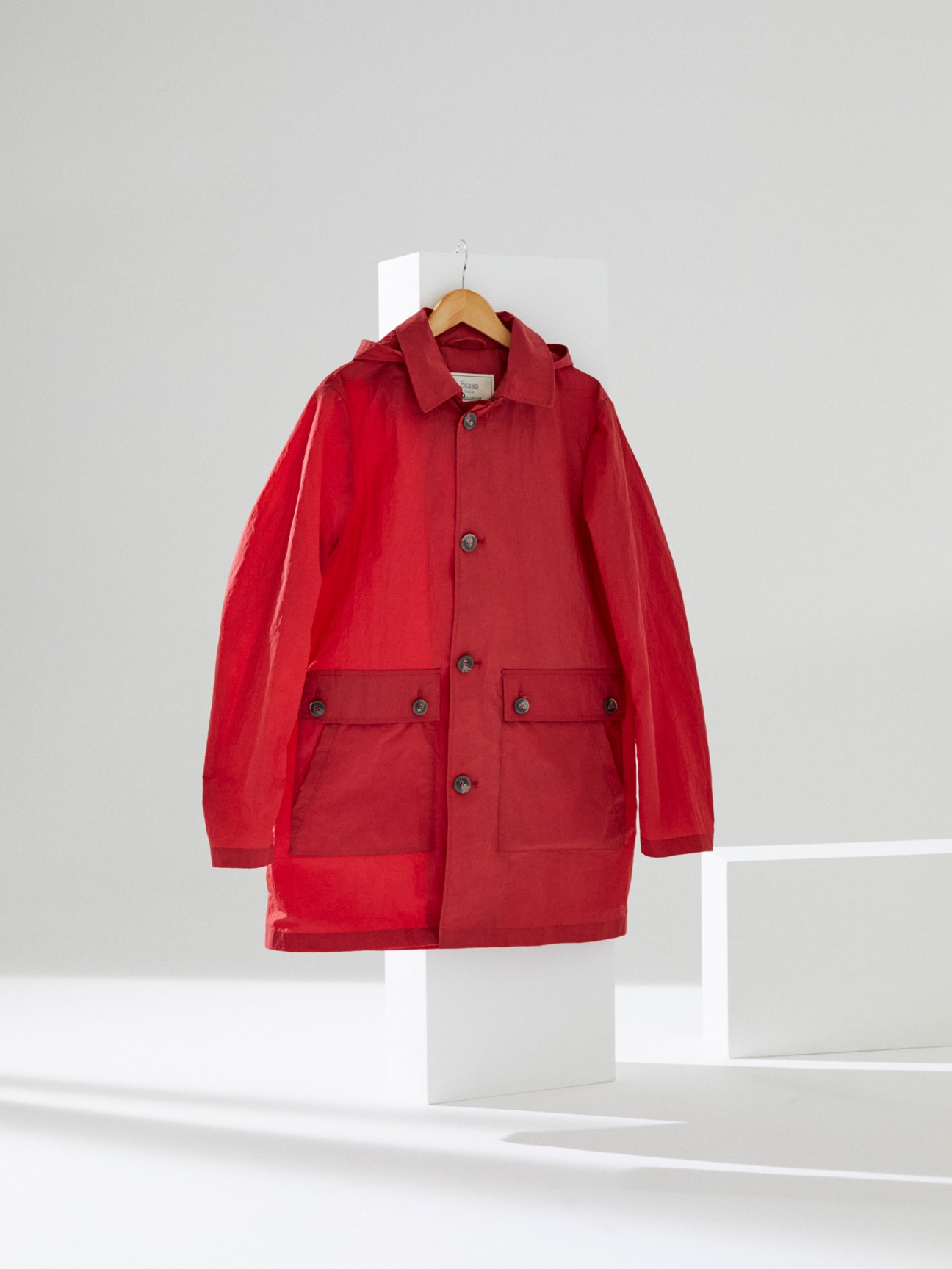 Red Herno Globe jacket hanging on wooden hanger against white background