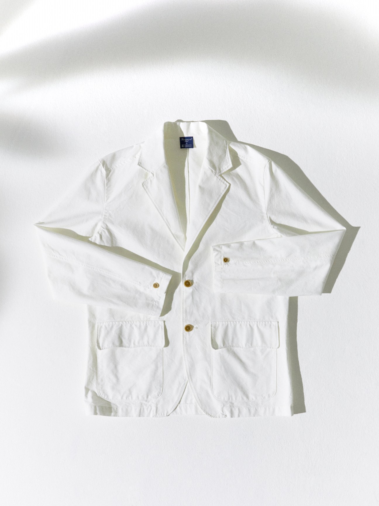 Light colored safari-style blazer with multiple pockets and structured design