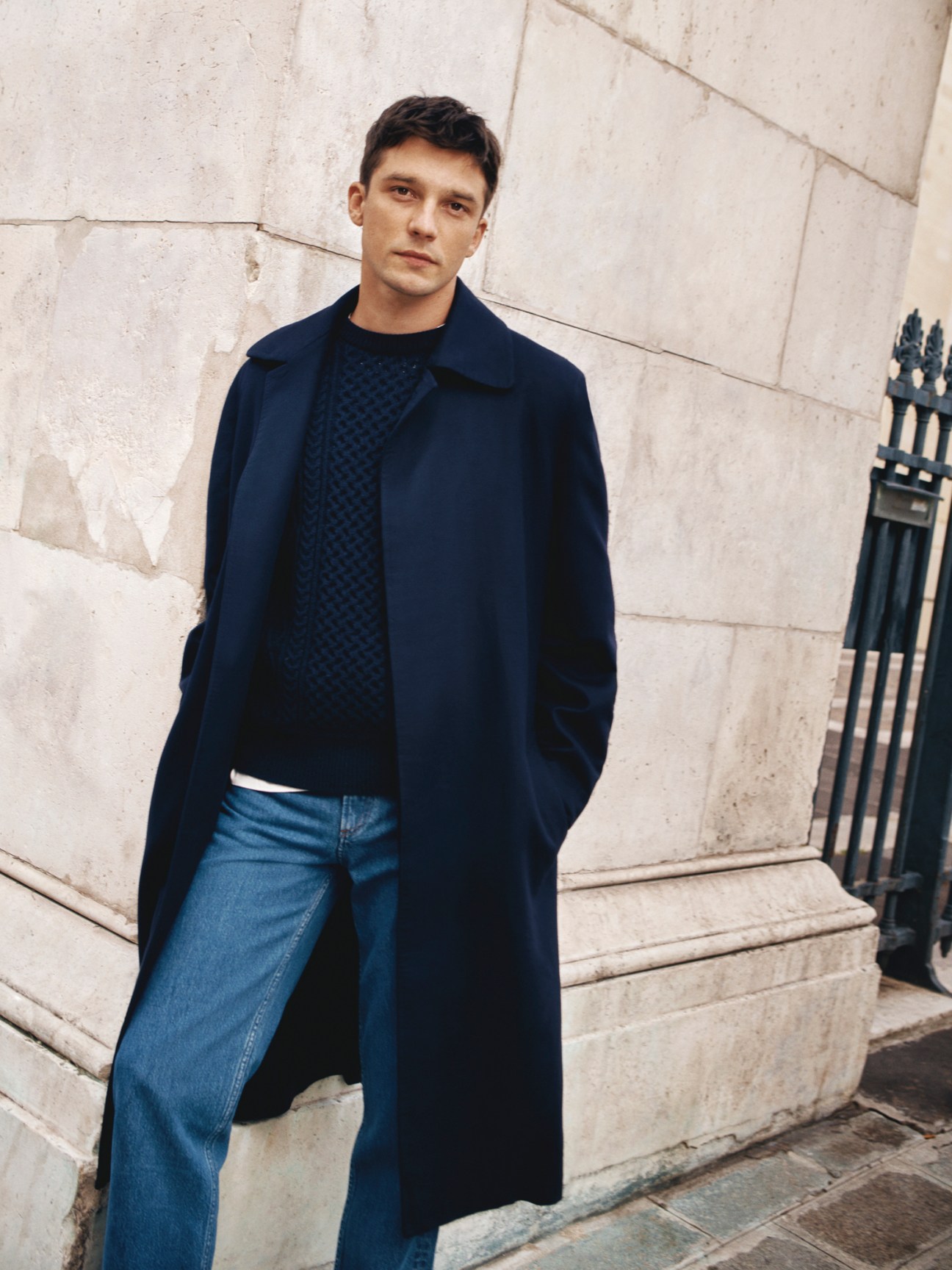 Model wearing navy wool coat over grey jumper with white t-shirt and dark jeans