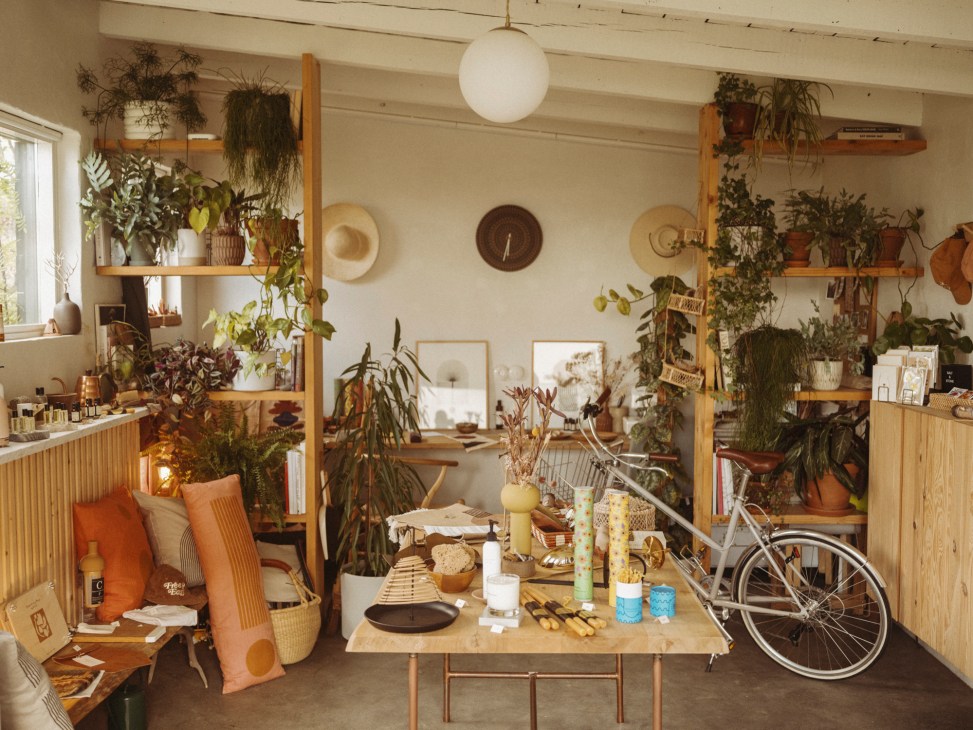 Close-up view of shelving displaying various artisanal products including ceramics, candles and homeware items