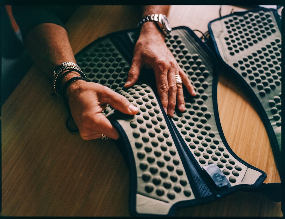 Close-up view of hands positioned on curved keyboard with distinctive perforated design featuring circular holes