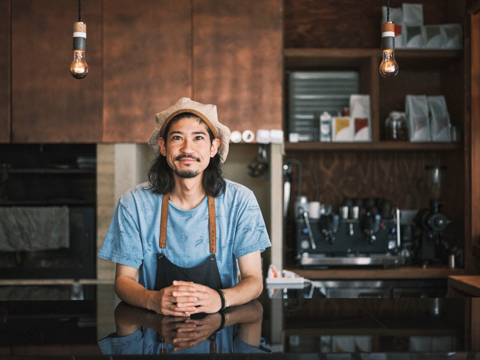 Shinichiro Suzuki, manager of Soil, standing in traditional Japanese shopping street