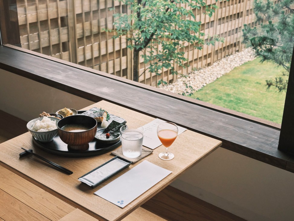 Traditional Japanese breakfast spread with rice, miso soup, grilled fish and pickled vegetables on wooden tray