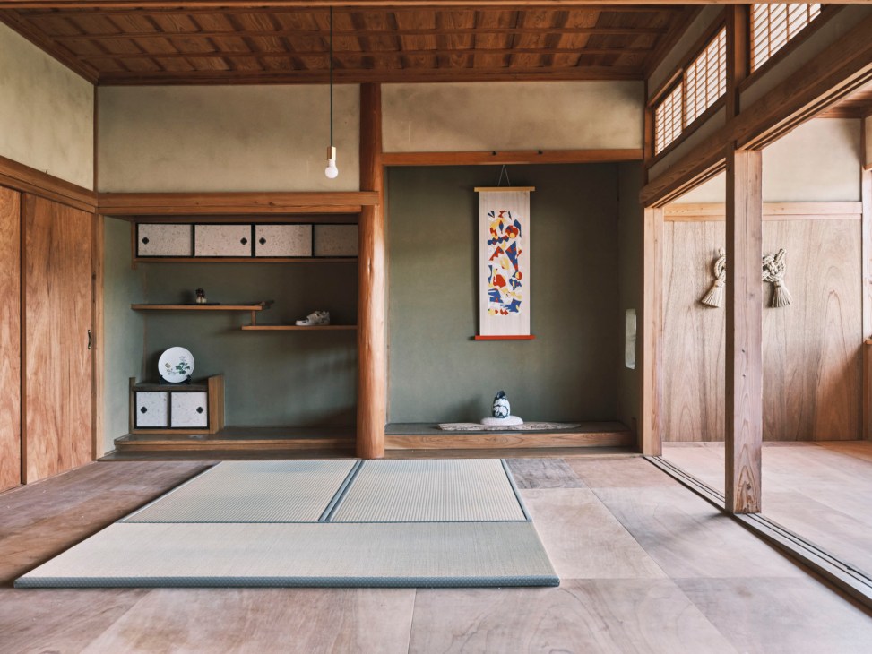 Traditional Japanese interior with tatami mats, wooden beams, sliding doors, and hanging scroll