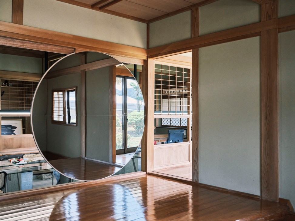 Interior of renovated Japanese house office featuring circular mirror and traditional wooden architecture