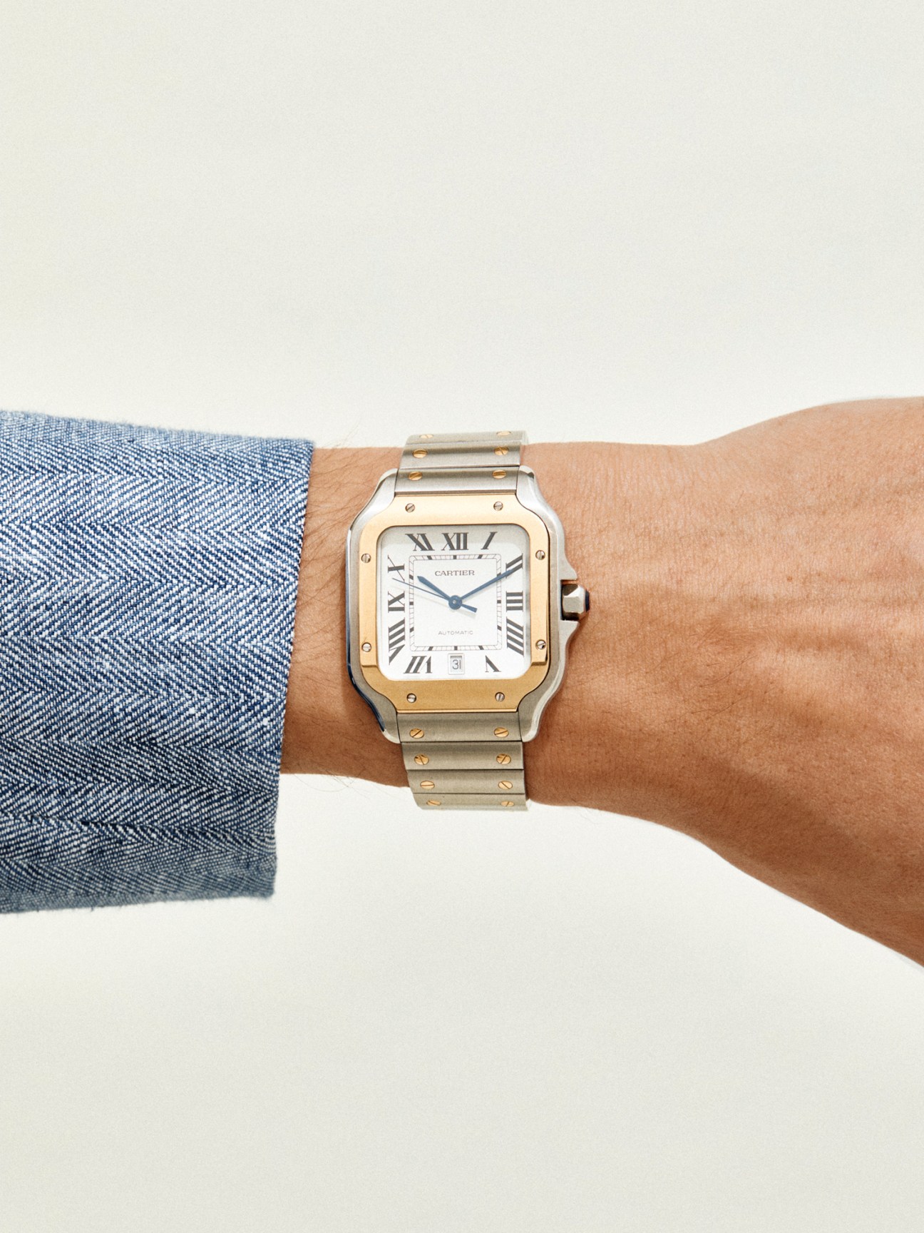 Santos de Cartier watch with distinctive square case design worn on wrist against neutral background
