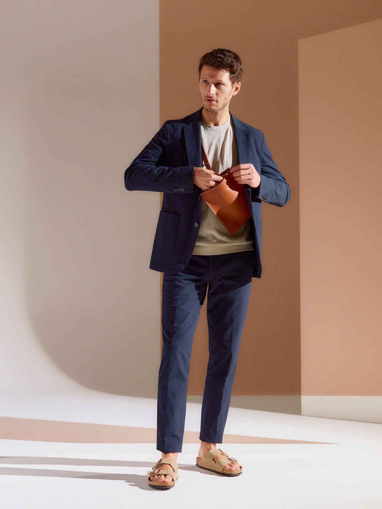Man wearing Fursac navy suit with relaxed styling and Birkenstock sandals