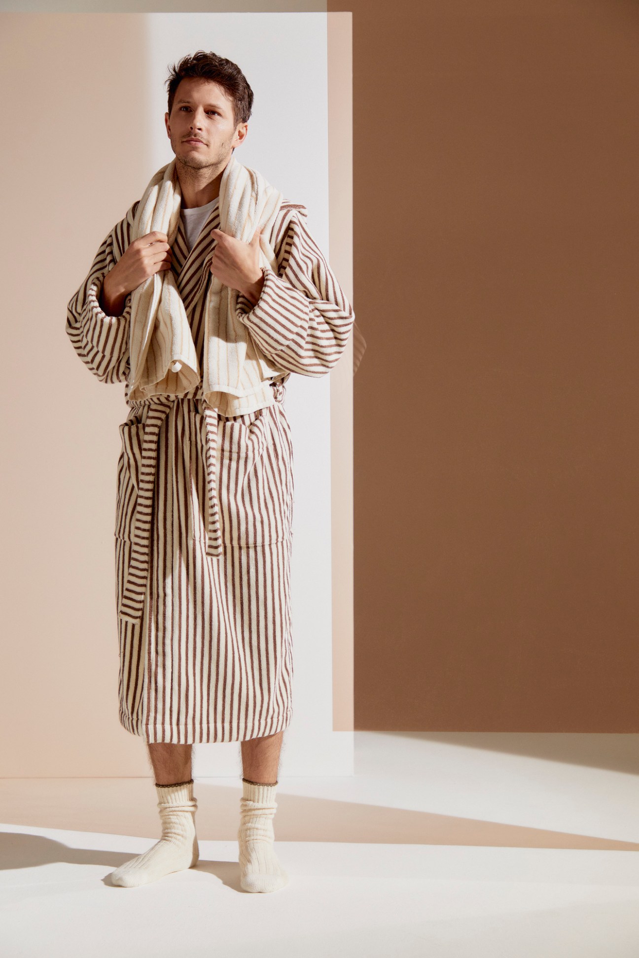 Man wearing striped Tekla bathrobe made from organic terry cotton