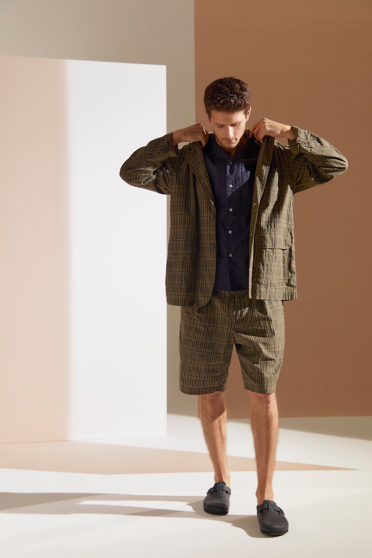 Man wearing Engineered Garments check shorts suit with navy shirt and sandals