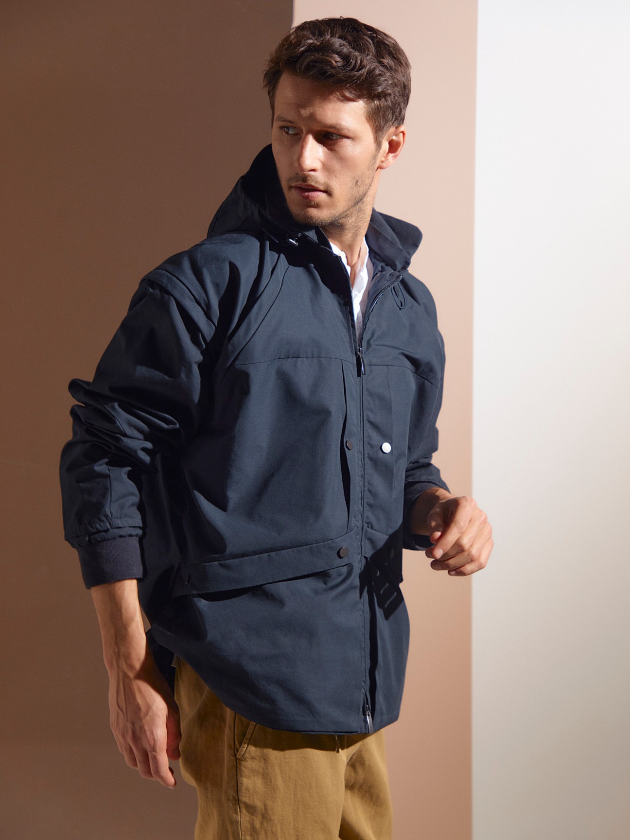 Man wearing navy hooded Konundrum Quarzit jacket with collar and hood combination