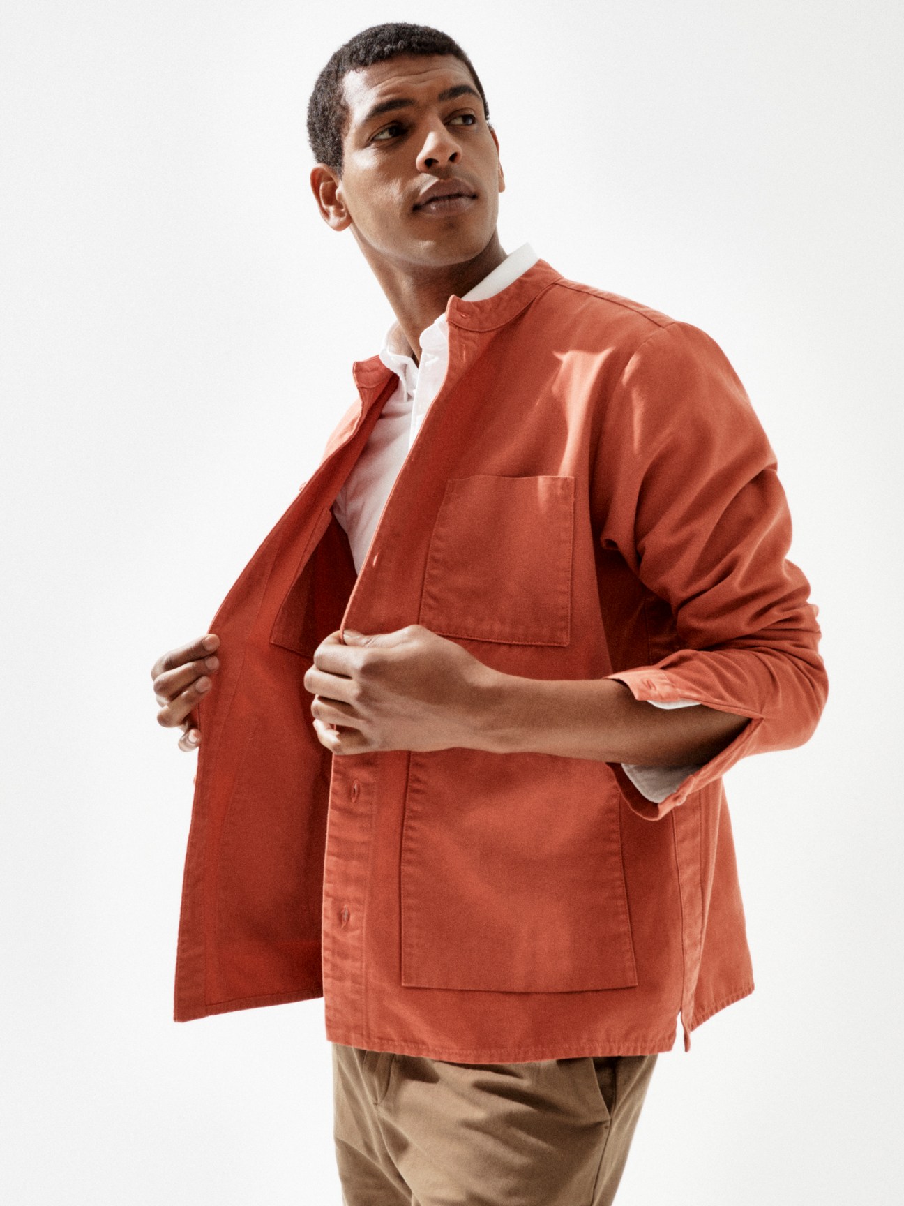 Model in oversized beige jacket with white shirt and dark trousers