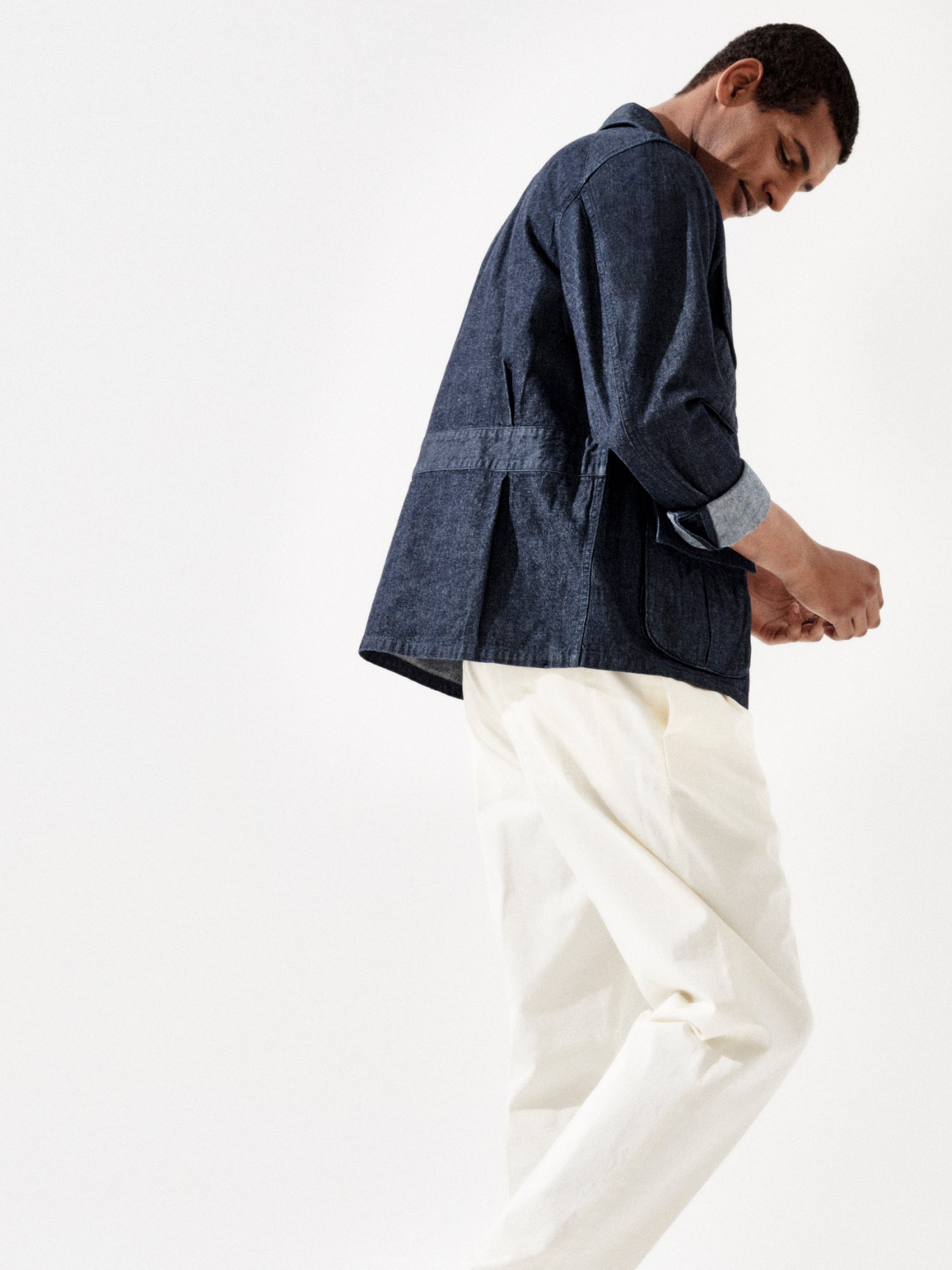Model in dark striped jacket with light colored trousers