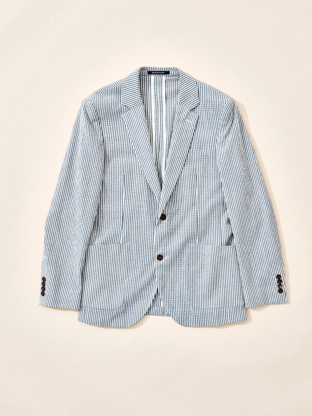 Blue and white striped seersucker blazer by Richard James displayed against neutral background
