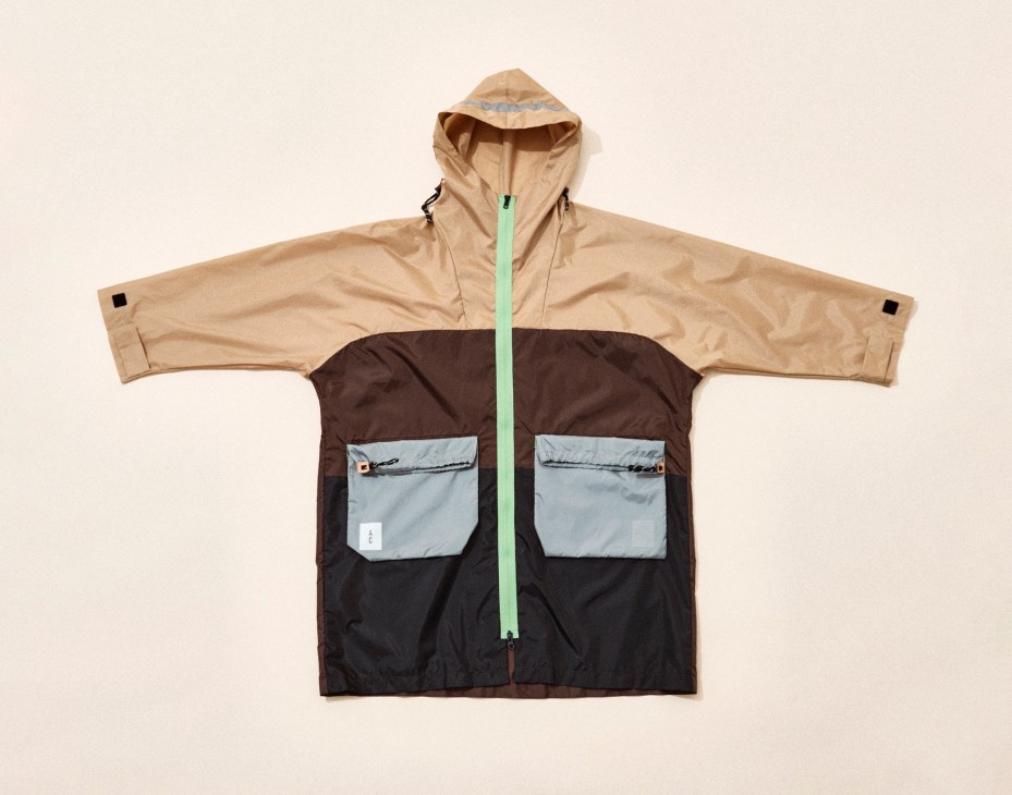 Color-blocked hooded jacket with beige top, brown middle, black bottom sections and mint green zipper by Ally Capellino