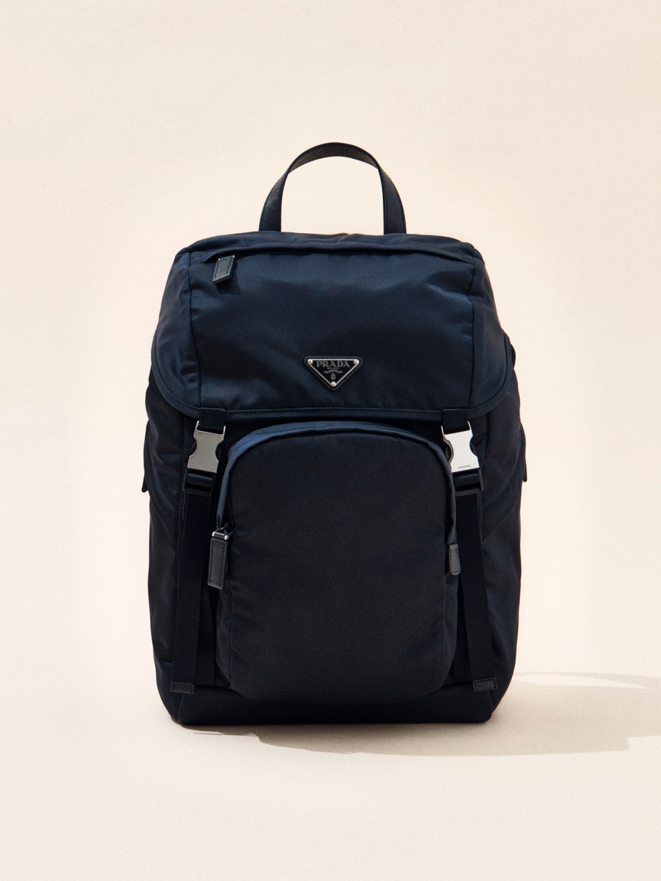 Navy blue nylon backpack with triangular Prada logo and multiple compartments