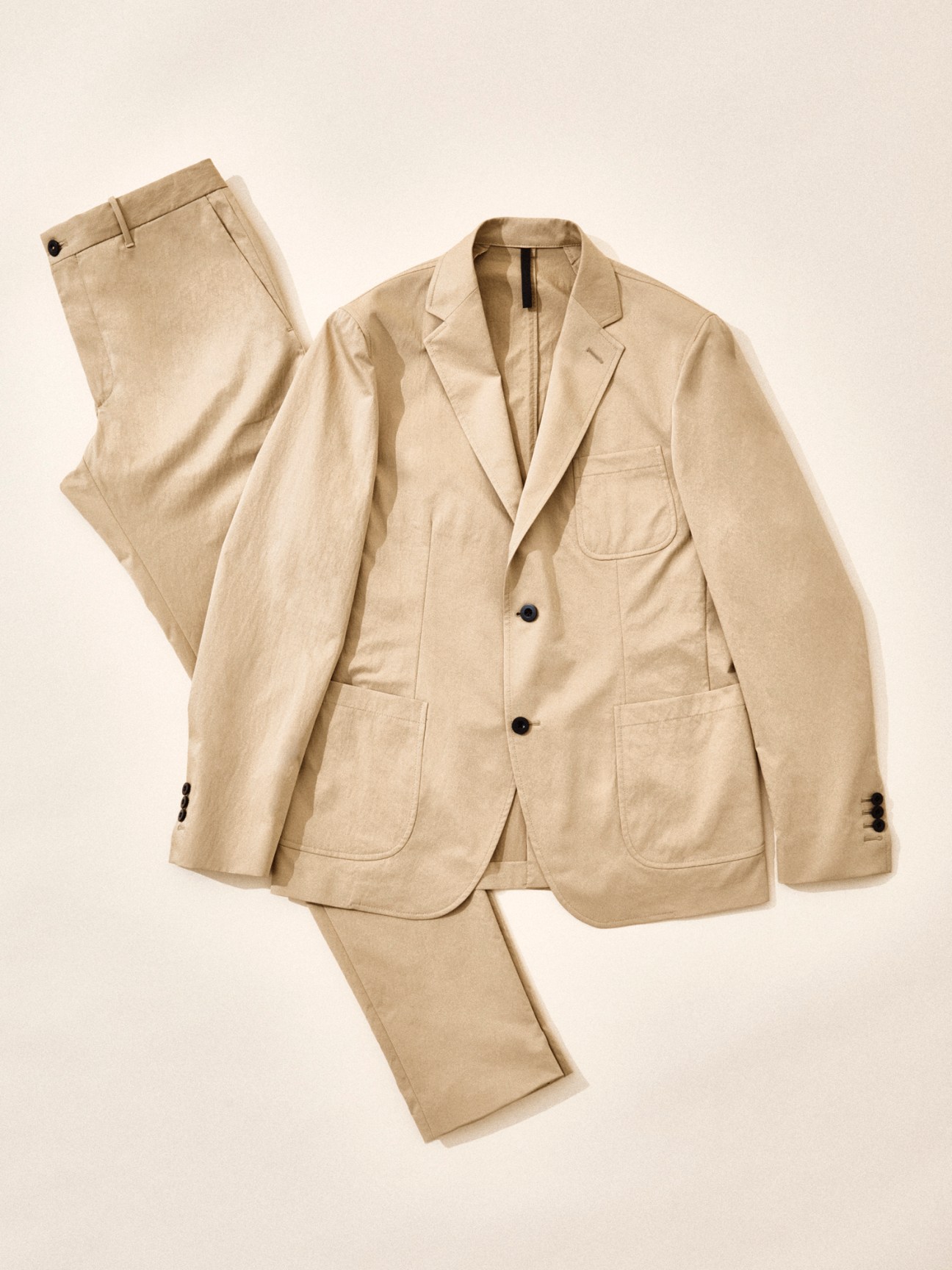 Beige suit jacket and matching trousers by Slowear displayed flat against neutral background