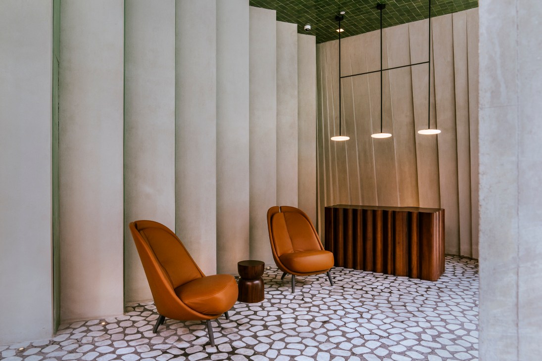 Modern interior with orange upholstered chairs, geometric floor tiles, and warm lighting in contemporary space