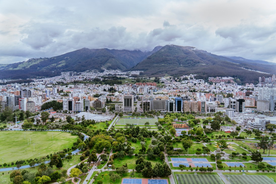 Aerial view of Quito showing urban development with mountains and La Carolina park in the background