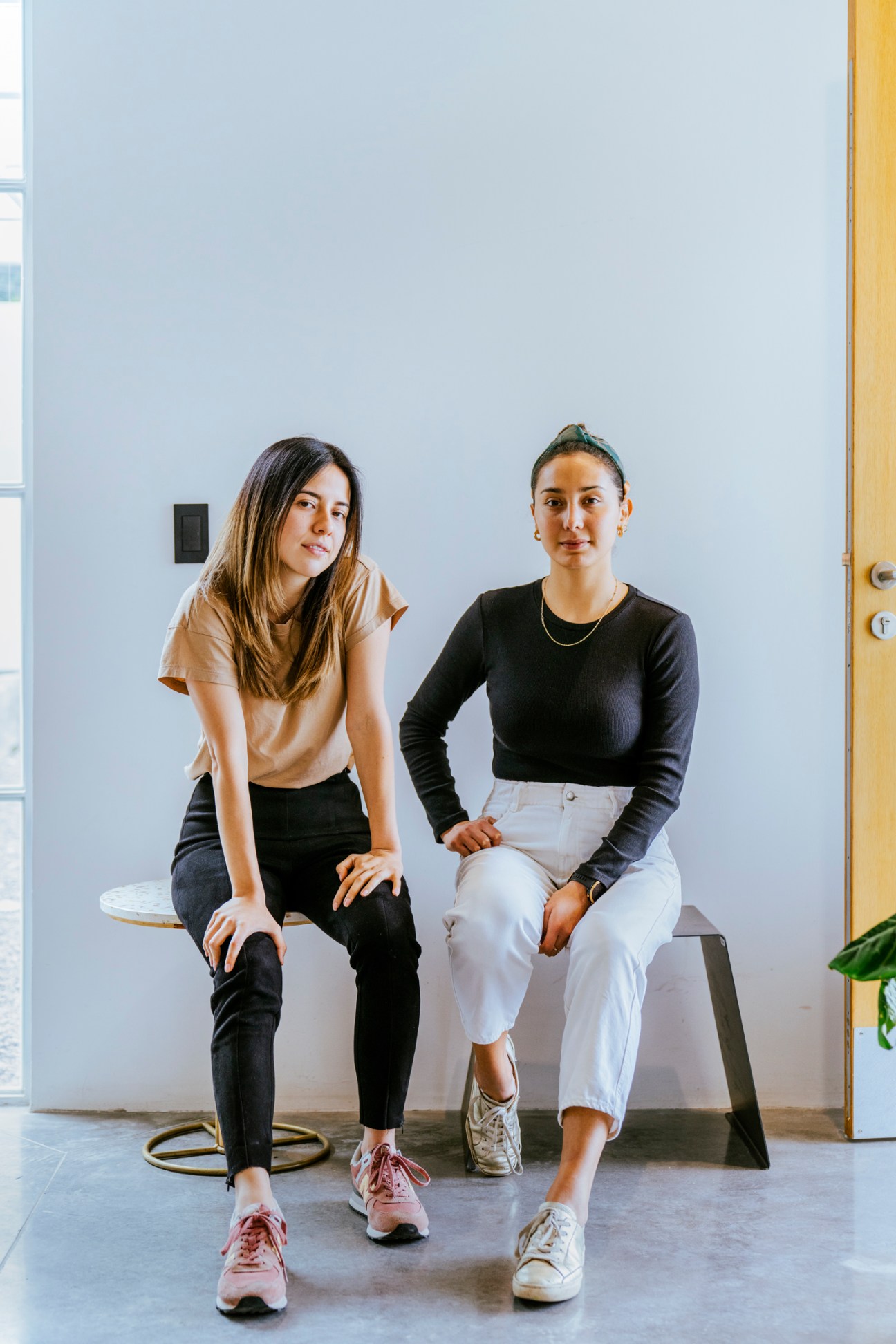 Ecuadorian designers Ángeles Ortiz and Raquel Espinoza sitting together in a modern interior space