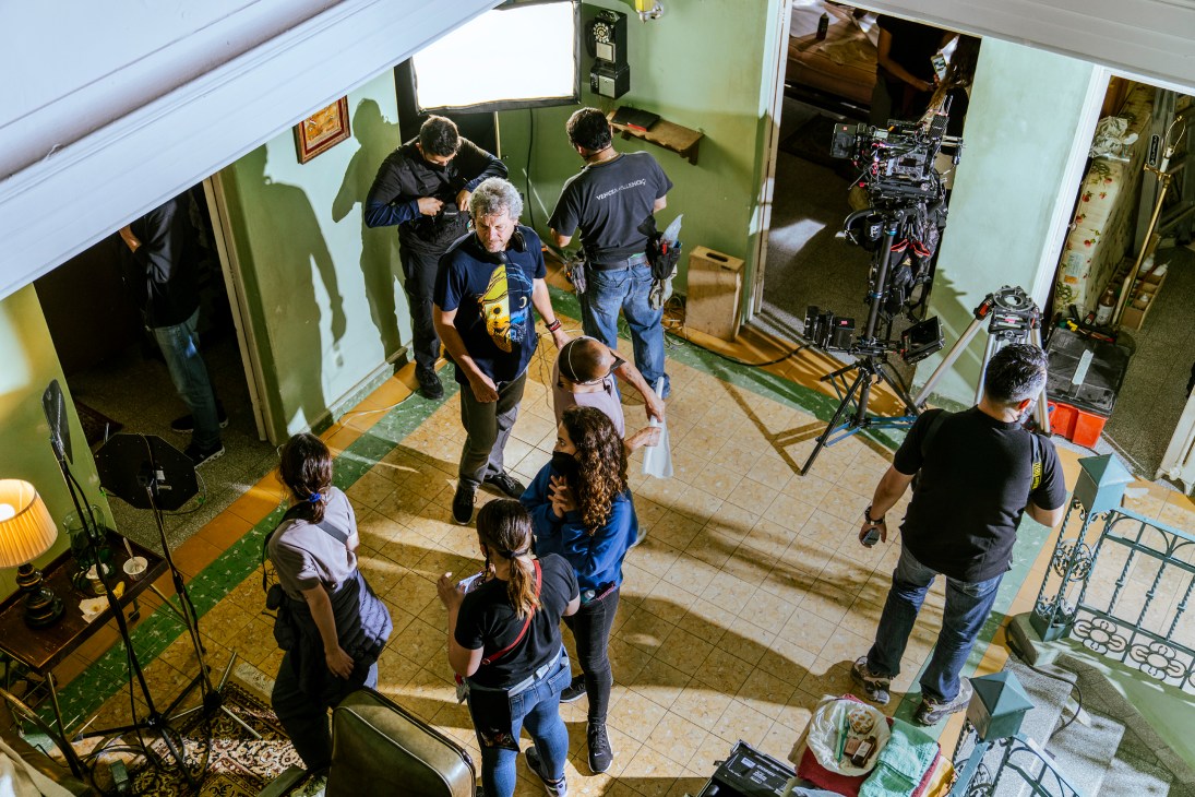 Film crew setting up lighting and camera equipment on the set of 'Travesuras de la Niña Mala' in Mexico City