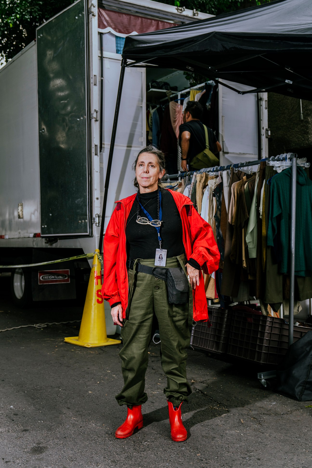 Adriana Olivera, head of wardrobe for 'Travesuras de la Niña Mala', stands in red jacket near costume trailer