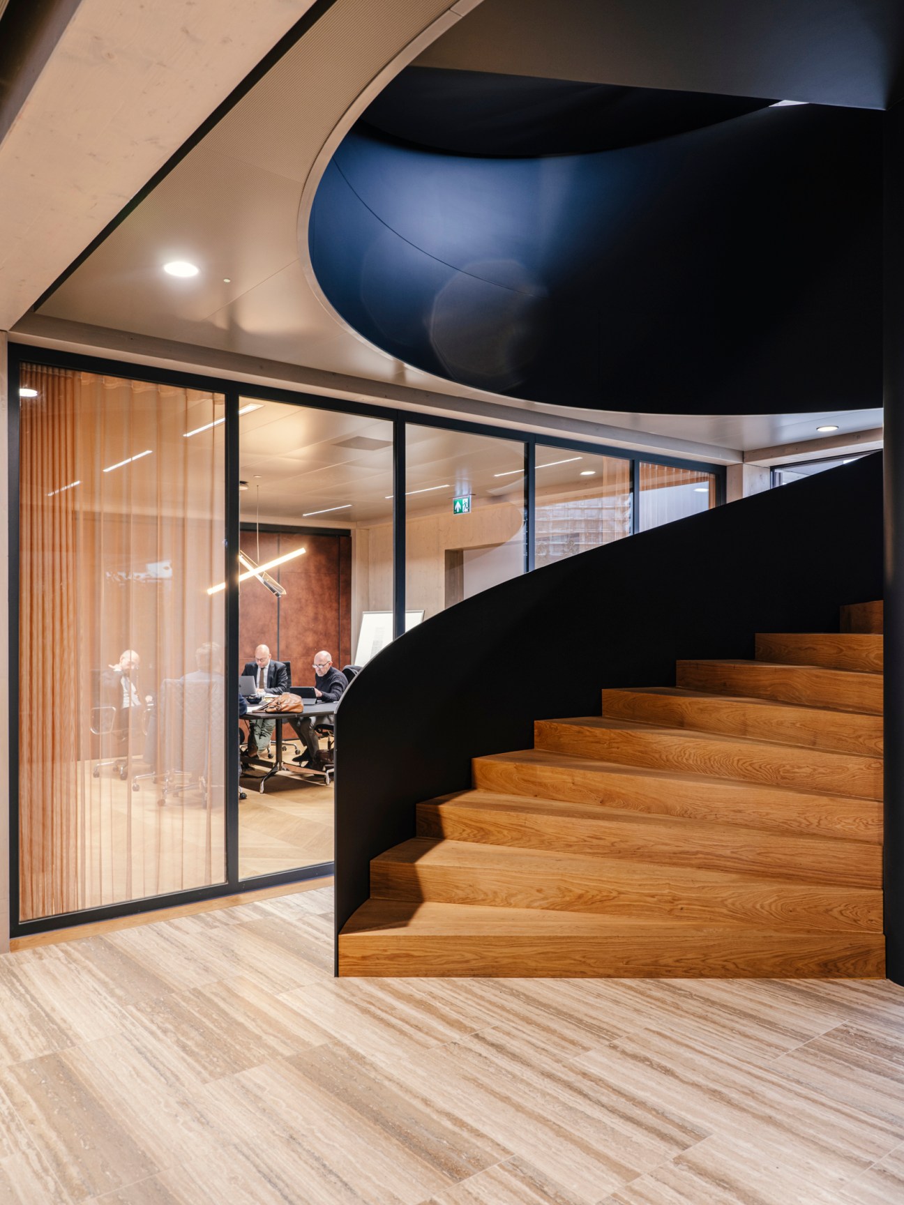 Curved wooden staircase with black steel railings inside Floating Office Rotterdam's modern timber-framed interior
