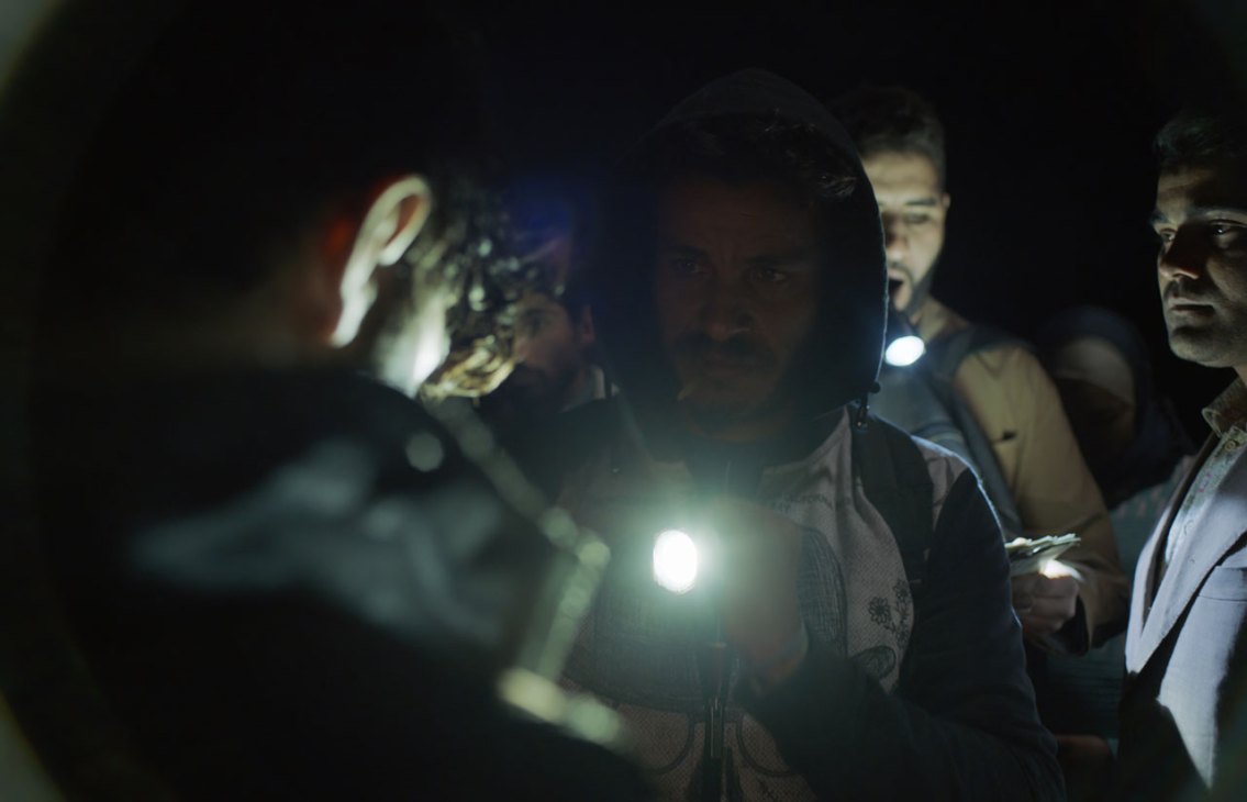 A man illuminated by flashlight in darkness from the film Europa
