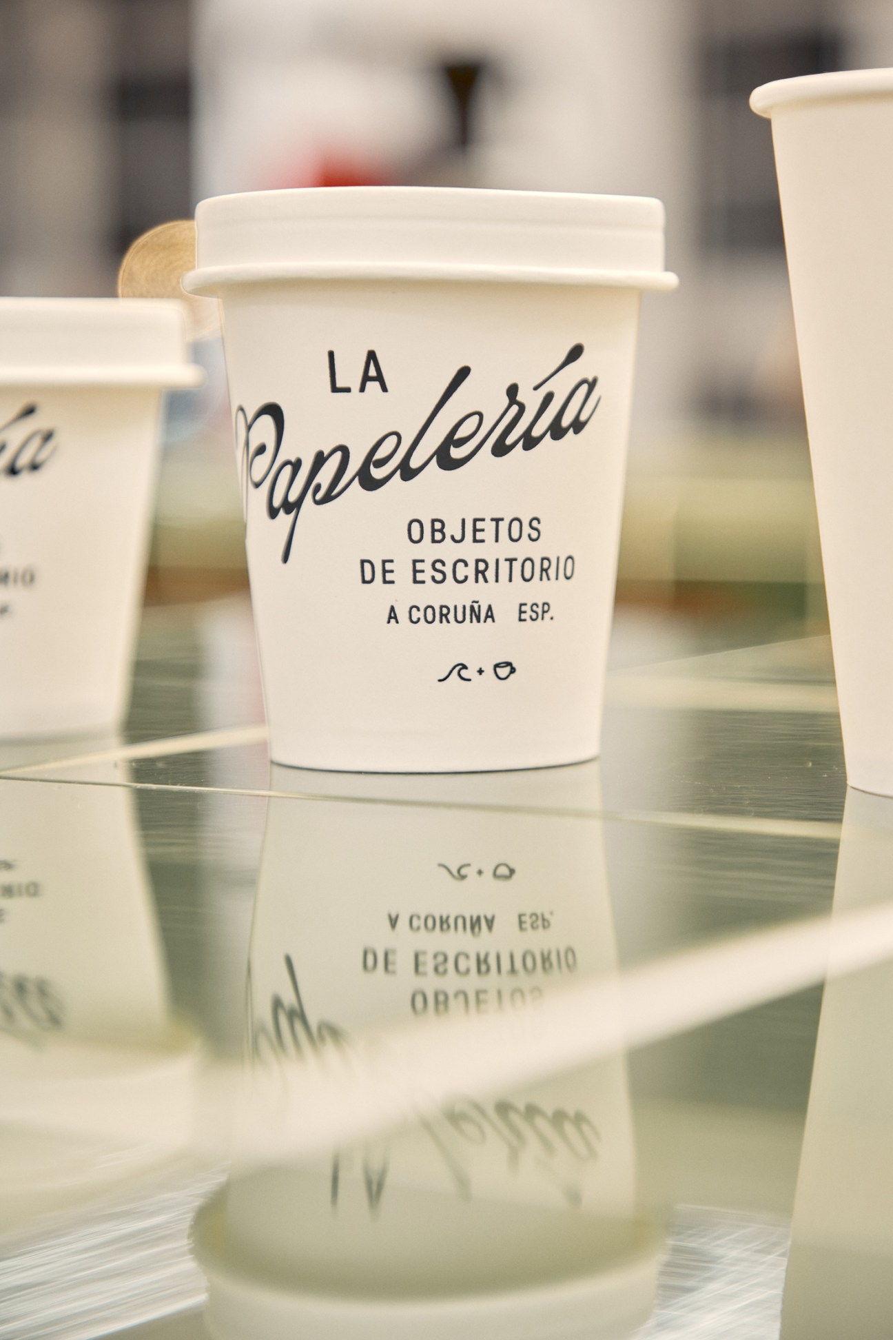 White containers with La Papelería branding showing distinctive typography and minimalist design