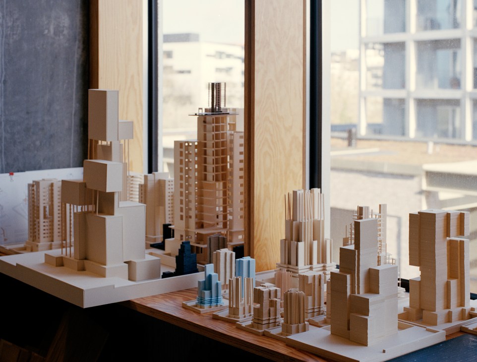 Wooden architectural models displayed on a windowsill with natural lighting