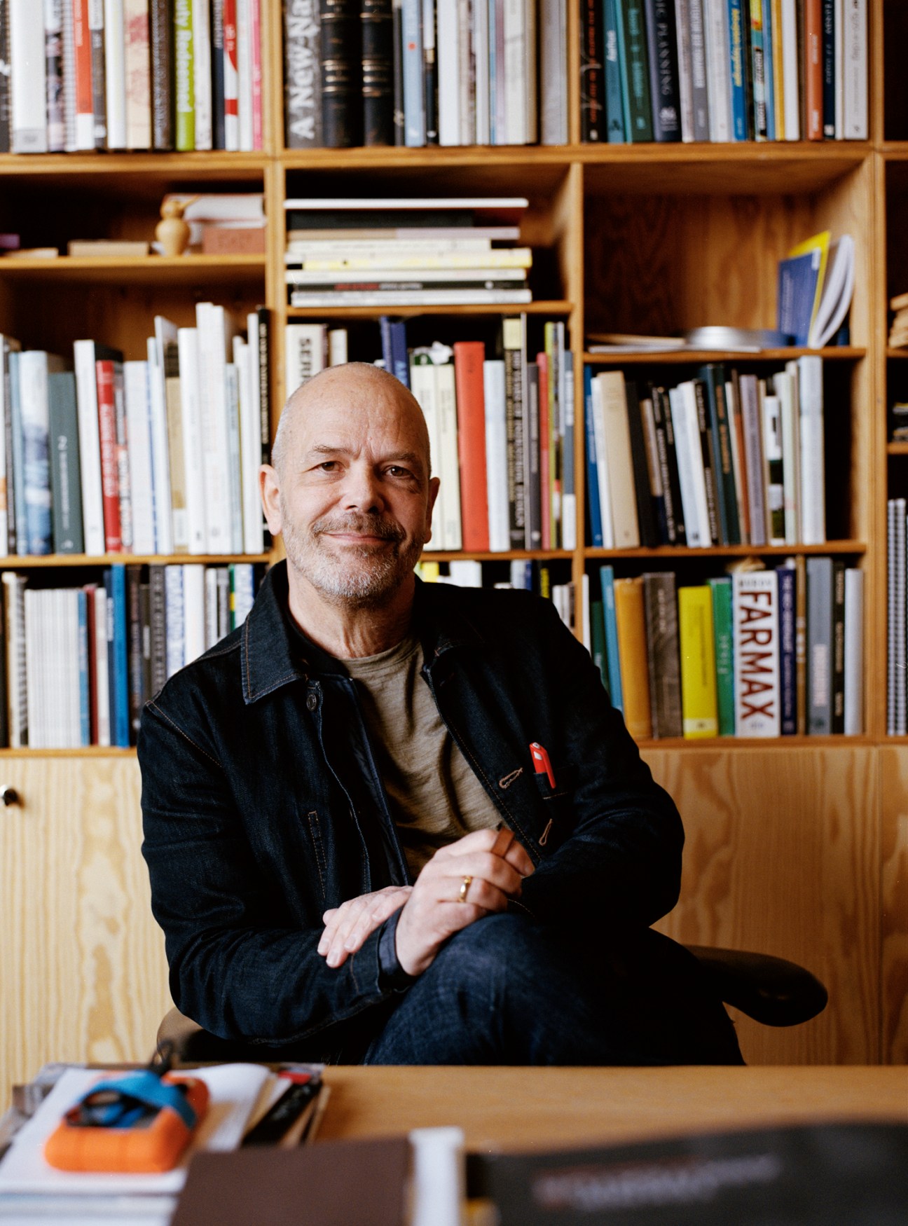 Torben Nielsen, dean of Aarch, sitting in his book-filled office with wooden shelving behind him