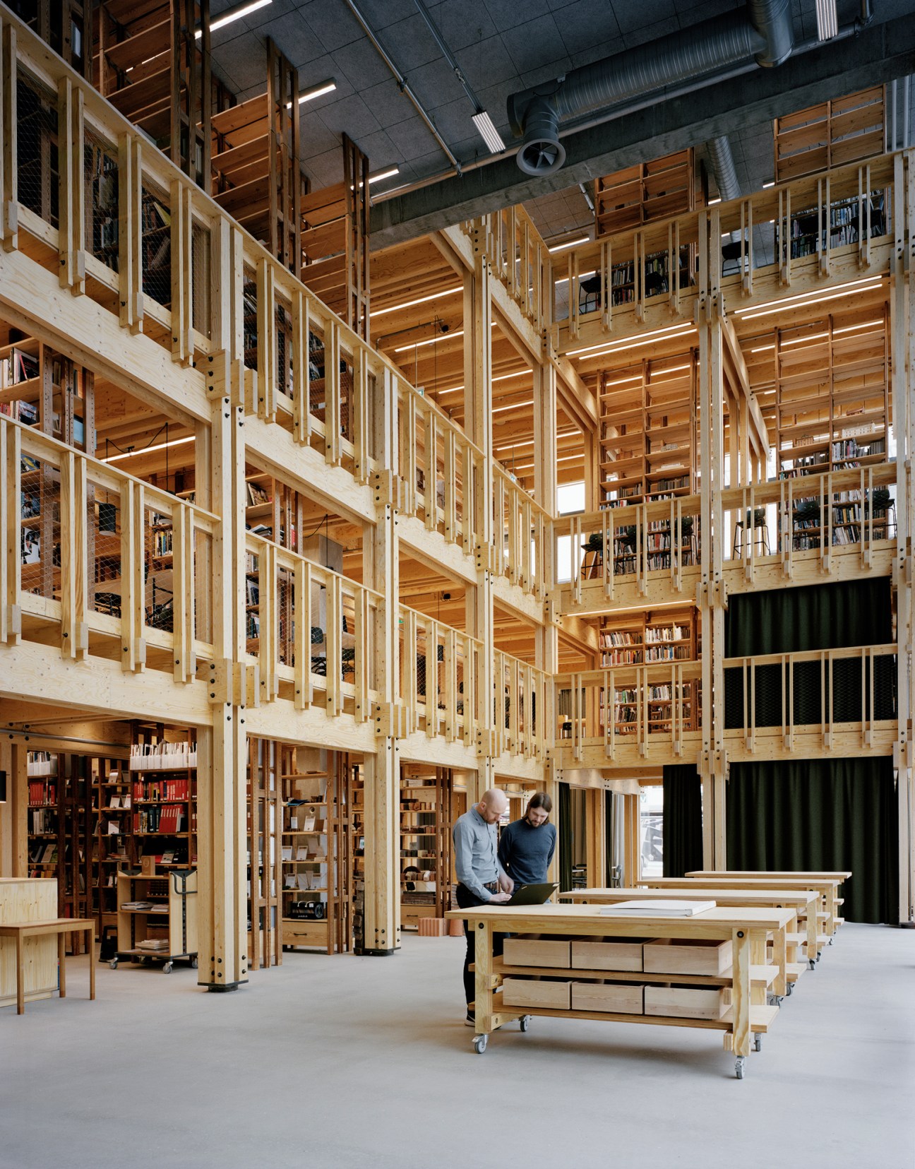 Multi-level timber library with wooden shelving and architectural materials designed by Praksis Architects