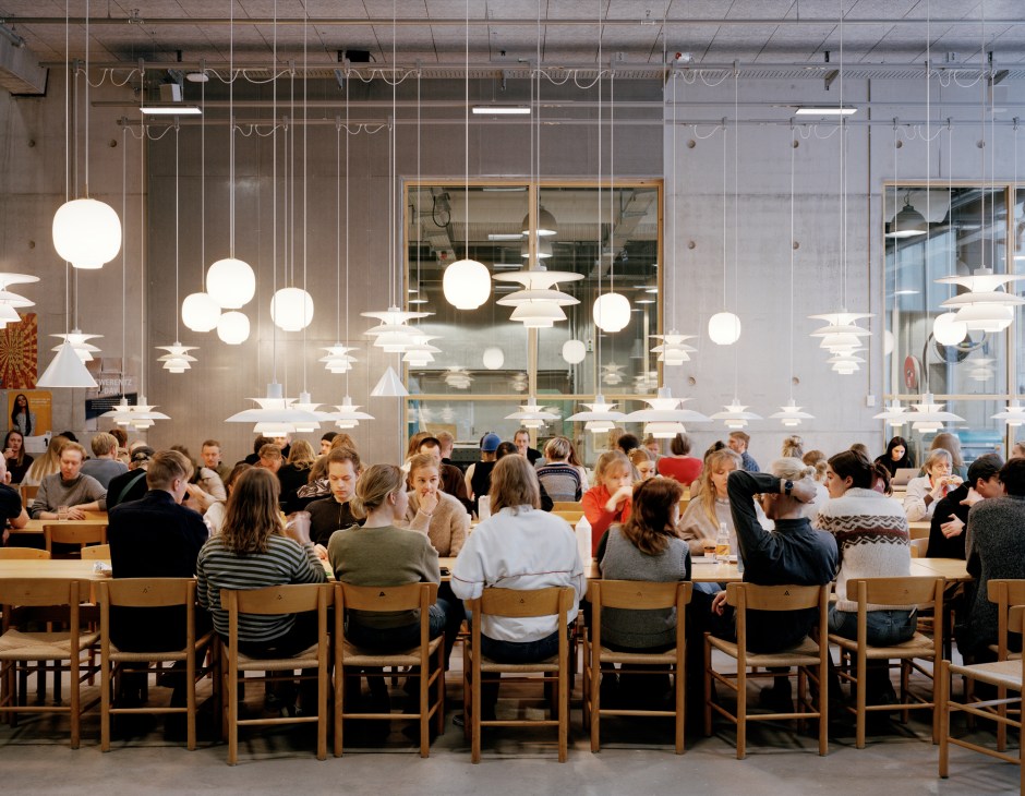 Students dining in the busy canteen during lunchtime with Louis Poulsen pendant lighting
