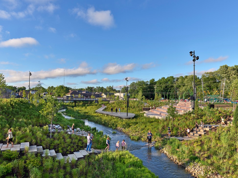 Grand Junction Park showing people enjoying a restored creek area with native plantings and stepped seating areas