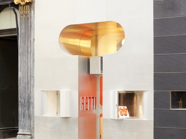 Modern storefront with golden sculptural canopy and white geometric facade displaying Fateeva branding