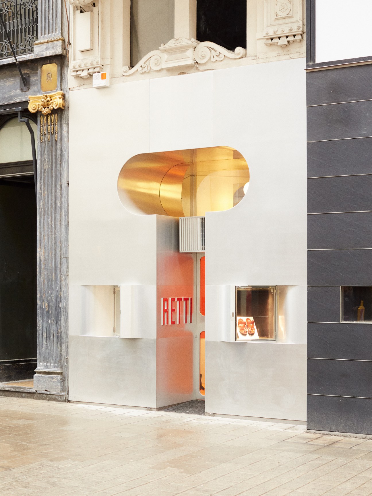 Modern storefront with golden sculptural canopy and white geometric facade displaying Fateeva branding