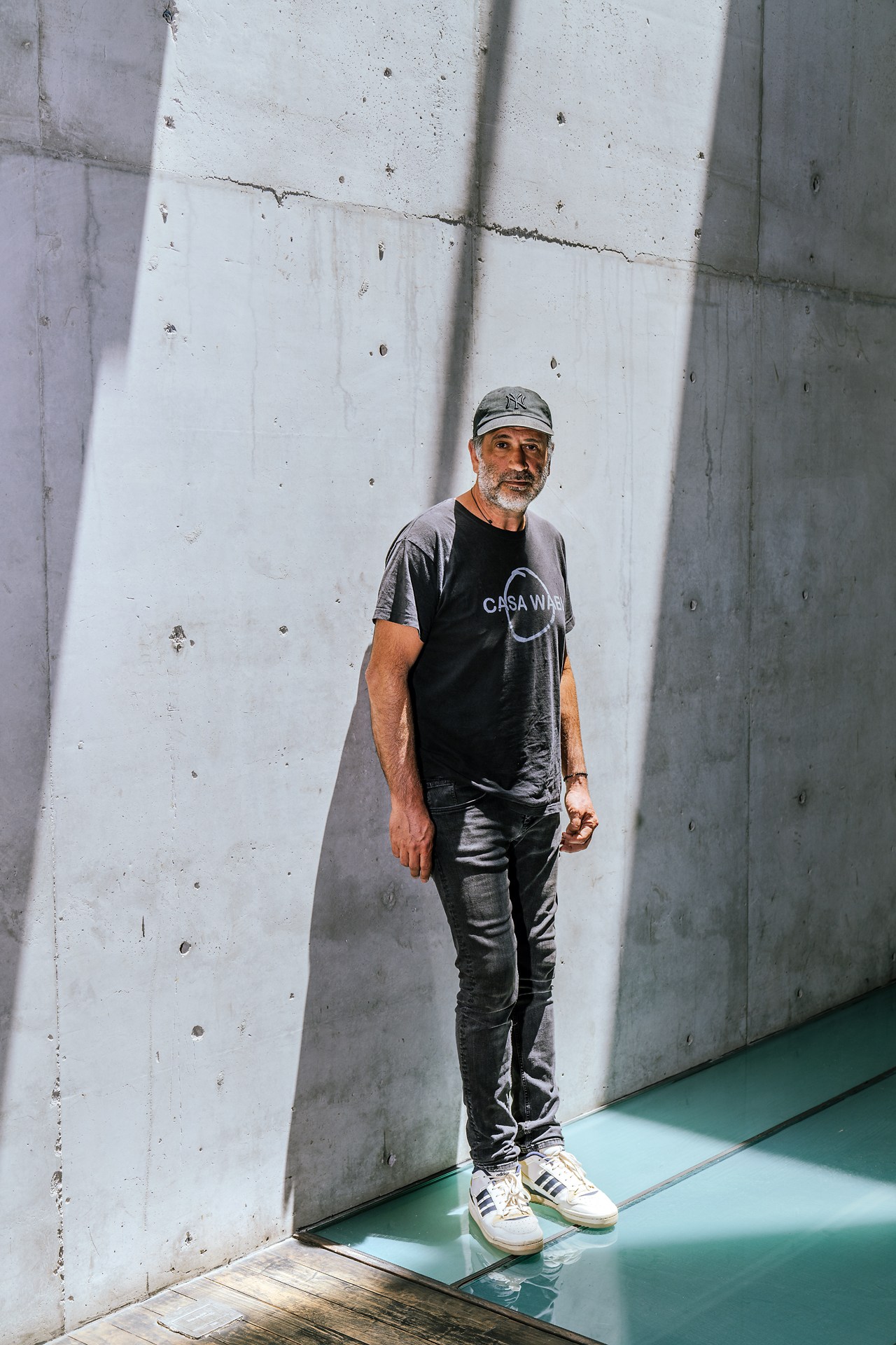 Bosco Sodi standing against a concrete wall in his Mexico City studio space.