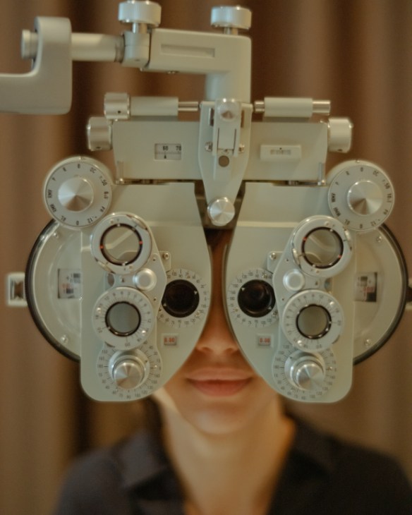Customer undergoing eye examination at Saturdays optician with professional equipment and staff member conducting the test