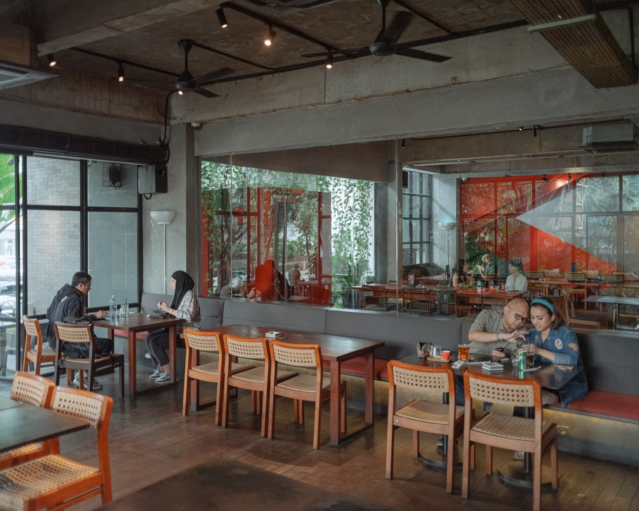 Interior of Tanamera Coffee showing wooden tables and chairs in modern café setting with warm lighting