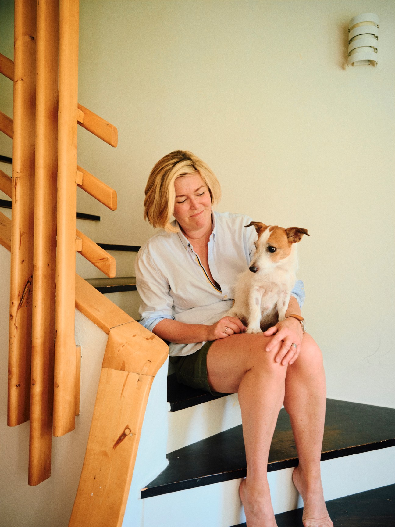 Portrait of Laura Aalto sitting in her restored Aalto apartment with period furniture and clean modernist interior