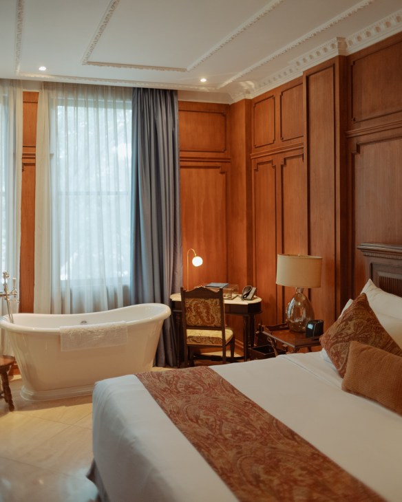 Luxurious guest room at The Gunawarman hotel featuring contemporary design with wood paneling and high-end furnishings