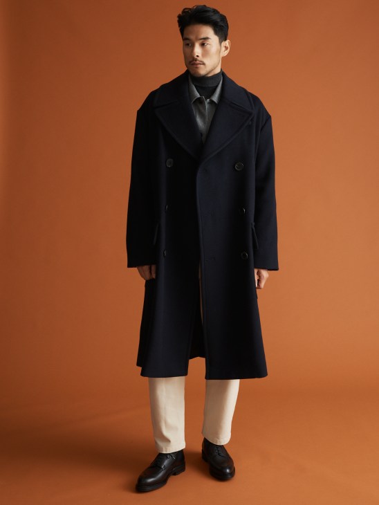 Model in luxury overcoat with layered formal wear