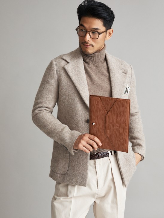 Model in formal tailored jacket with rollneck jumper and accessories