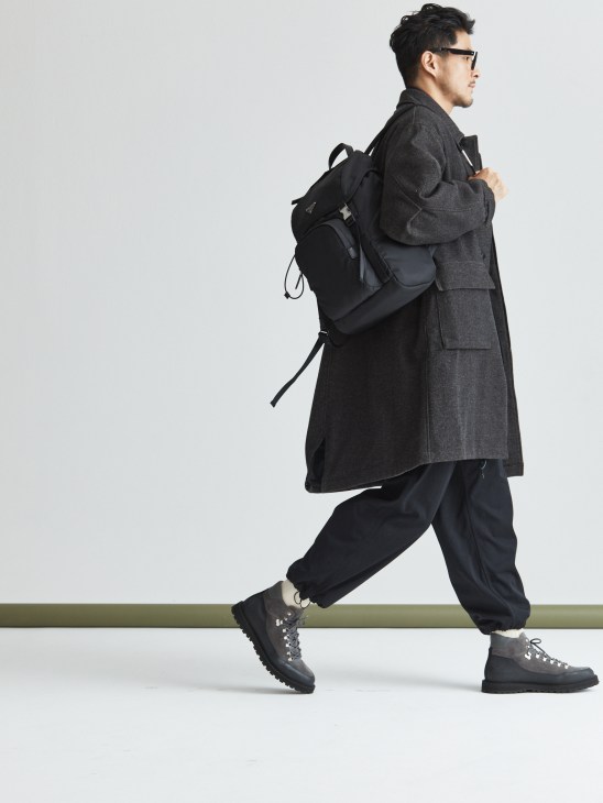 Model in oversized coat with backpack and boots