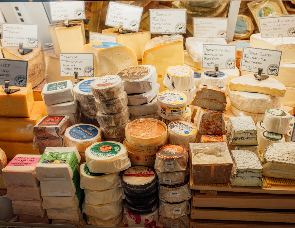 Display of artisanal cheeses with labels at The Cheese Shop in Des Moines.