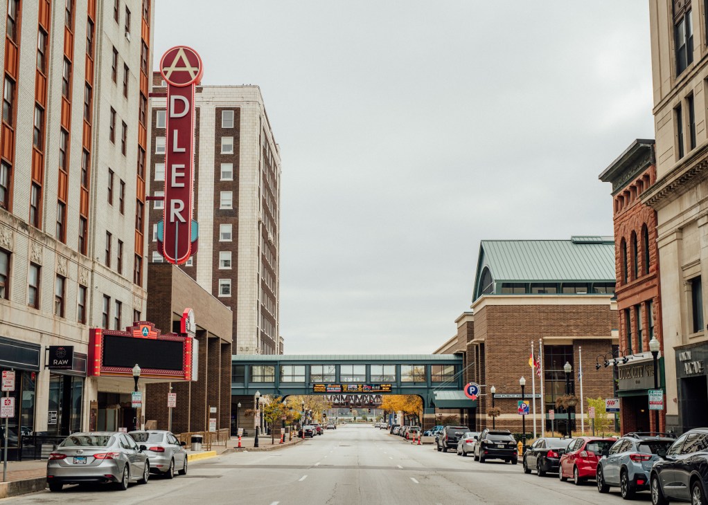 Downtown Davenport street with historic buildings, vintage neon theater sign, and parked cars